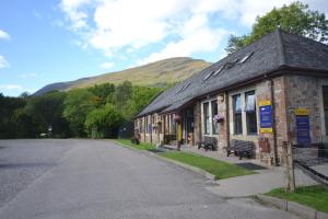 a building on the side of a road with a mountain at Blackwater Hostel in Kinlochleven