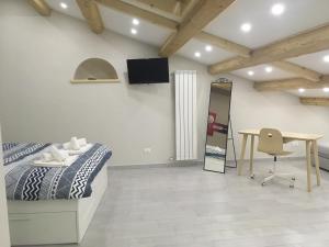 - une chambre avec un lit, un bureau et un miroir dans l'établissement Sagittabondo, à Campobasso