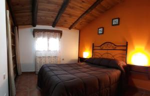 a bedroom with a large bed and a window at Casa Aldea in Griegos