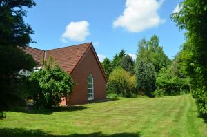 a small red church with a large grass yard at Gästehaus Vigliarolo gewerblich Jedes Zimmer eigenes Bad Gemeinschaftsküche in Elmshorn