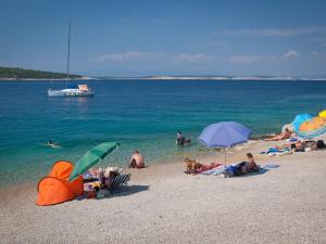 grupa ludzi leżących na plaży z parasolami w obiekcie Apartment in Silo/Insel Krk 13588 w mieście Šilo +4 zdjęcia