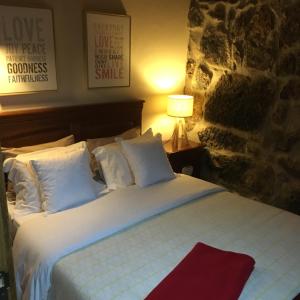 1 cama con sábanas blancas y almohadas en una habitación en Cantinho da Du, en Lamego