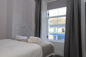 a bedroom with a bed and a window at Dollar Apartments-39 Bridge Street in Dollar