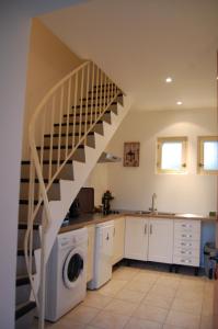 una cocina con lavadora y una escalera en Gîte dans un Domaine Historique, en Chevreuse