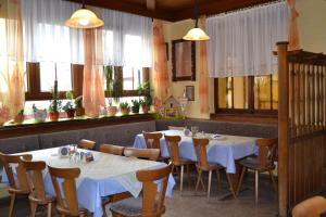 a restaurant with white tables and chairs and windows at Landgasthof Hock in Großostheim