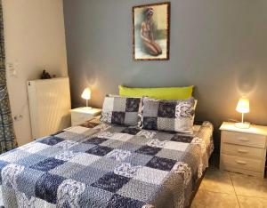 sypialnia z łóżkiem z 2 stolikami nocnymi i 2 lampami w obiekcie Menelaos Apartments w Adelianos Kampos