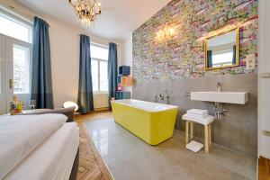 ein Badezimmer mit einer gelben Badewanne und einem Waschbecken in der Unterkunft Leuhusen Collection Vienna in Wien
