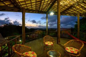 a porch with chairs and a view of the sunset at Lago Hotel in Pipa