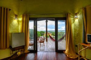 Habitación con una puerta corredera de cristal que da a un balcón. en Lago Hotel, en Pipa