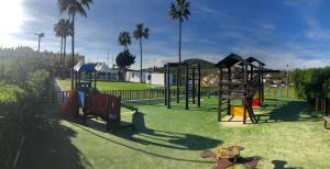 un parque con parque infantil con juegos y palmeras en Alta Loma Costa, en Fuengirola