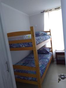 two bunk beds in a room with a window at Departamento temporada in Coquimbo
