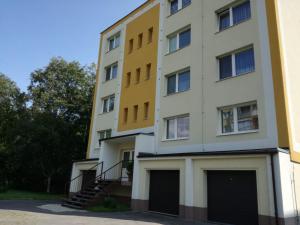 un grand bâtiment blanc avec un jaune dans l'établissement Mountain View Apartment, à Štôla
