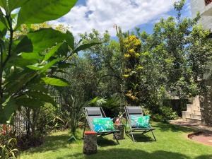 two chairs sitting on the grass in a garden at Guesthouse Bianca in Rio de Janeiro