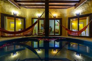 a swimming pool with a hammock in a house at Lago Hotel in Pipa