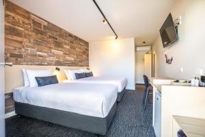 a hotel room with two beds and a tv at Nightcap at Westside Hotel in Laverton