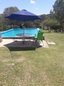 una mesa y una silla con sombrilla junto a la piscina en Rancho Don Juan en 