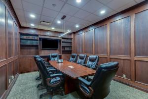 a conference room with a wooden table and leather chairs at The Thompson Hotel in Kamloops +34 photos
