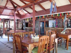 comedor con mesas y sillas de madera en SiBoya Bungalows, en Siboya