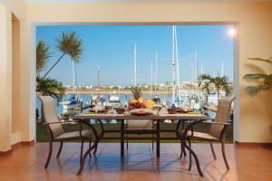 a dining room with a table and a view of a marina at Isla Mazatlan Residence Club in Mazatlán