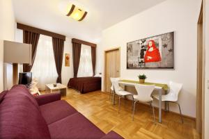 ein Wohnzimmer mit einem lila Sofa und einem Tisch in der Unterkunft Salvator Superior Apartments in Prag