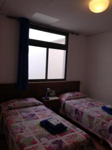 タサコルテにあるVivienda vacacional Tazacorte Céntricoのベッドルーム1室(ベッド2台、窓付)