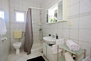 un bagno bianco con lavandino e WC di Apartments Mara a Supetar (San Pietro di Brazza) Altre 45 foto