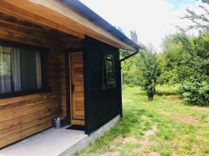 a wooden cabin with a door on the side at Nube Austral Patagonia in Cochrane