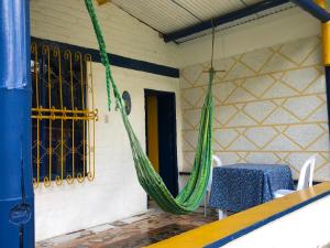 a hammock in a room with a table and chairs at Posada La Loca Compañía in Salento