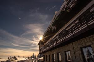 多爾尼羅姆納的住宿－Horský hotel Kozubová，天空中闪烁的太阳建筑