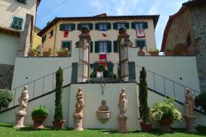 a house with statues in front of it at Anacleto via Castello 48 in Collodi