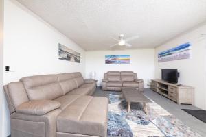 a living room with a couch and a tv at Oceancrest 10 in Forster