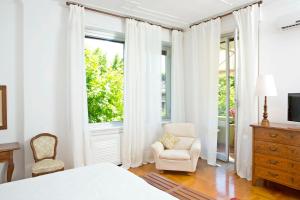 a bedroom with a bed and a chair and a window at B&B Albaro in Genova