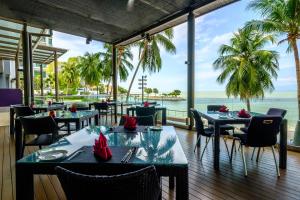 乔治市Mercure Penang Beach的一间有桌椅、可欣赏海景的餐厅