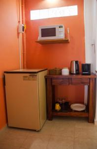 a small kitchen with a microwave and a refrigerator at La Quintina in Allen