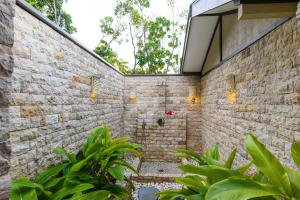 um chuveiro exterior numa parede de tijolos com plantas em Mantaray Island Resort em Nanuya Balavu Island