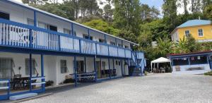 un bâtiment bleu et blanc à côté d'un bâtiment jaune dans l'établissement Whangaroa Lodge Motel, à Whangaroa