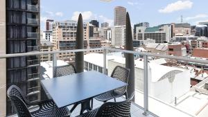 a table on a balcony with a view of a city at Oaks Adelaide Embassy Suites in Adelaide