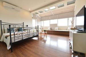 1 dormitorio con 1 cama y sala de estar en Penghu Chenhi Bay Homestay, en Baisha