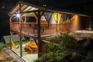 a large wooden cabin with a deck at night at Les Bungalows de la Sucrerie in Le François