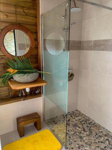 a shower with a glass door in a bathroom at Les Bungalows de la Sucrerie in Le François