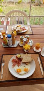 un tavolo per la colazione con uova, pancetta e pane tostato di Nuch's Apple Guest House a Si Bun Ruang