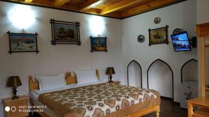 a bedroom with a bed and some pictures on the wall at Rabat Boutique in Samarkand