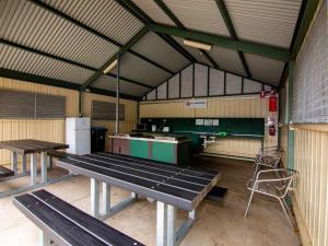 a gym with two picnic tables and a refrigerator at Windsor Gardens Caravan Park in Adelaide