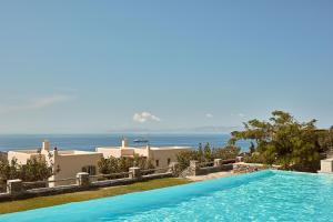 a swimming pool in front of a villa at Diles & Rinies in Tinos