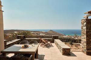 a patio with a table and a view of the ocean at Diles & Rinies in Tinos