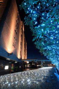ein Gebäude mit blauen Lichtern vor einem Baum in der Unterkunft Hotel Cherena Kunitachi (Adult Only) in Kunitachi