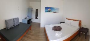 a bedroom with two beds and a table with a chair at Positano Alona Beach Panglao in Panglao