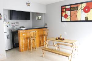 cocina con mesa, 2 sillas y barra en Apartamentos Arpushana, en Ríohacha