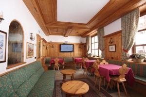 a restaurant with a green couch and tables and chairs at Park Hotel Sport in Andalo