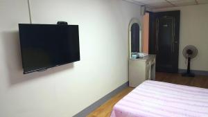 a bedroom with a flat screen tv on the wall at Fu Da Guest House in Hualien City